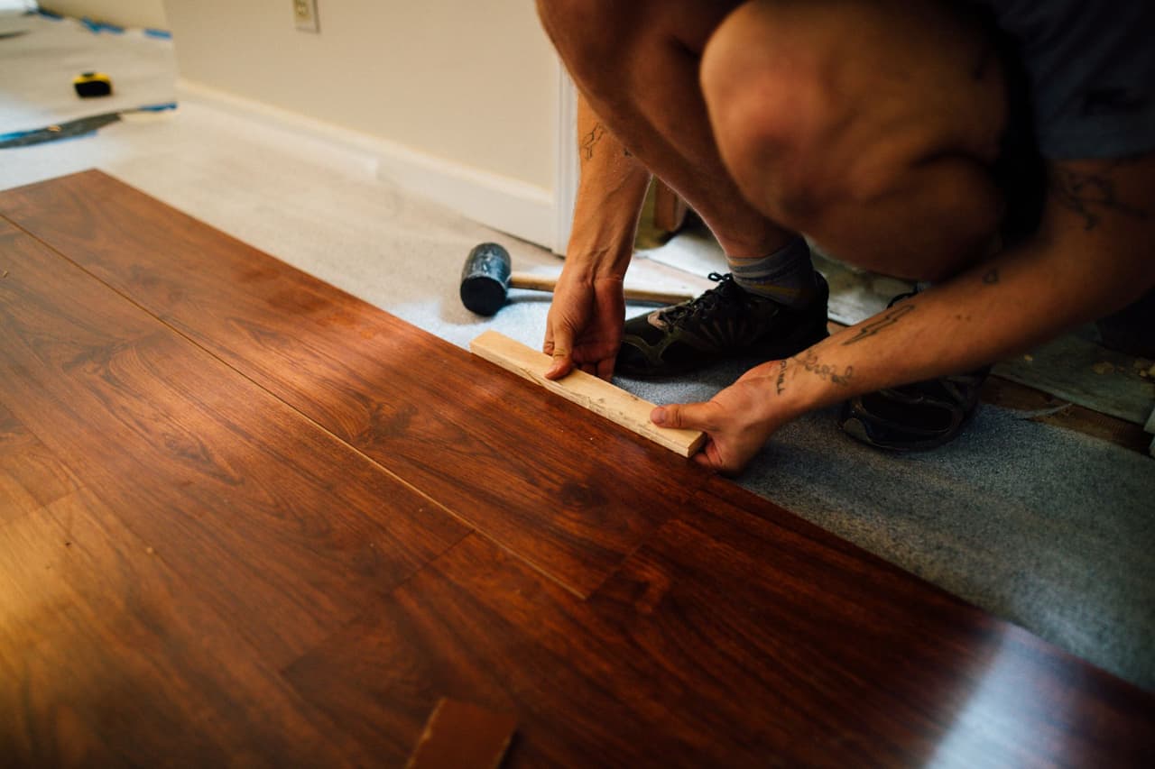 Flooring installer fitting a plank floor during a Memphis-area installation