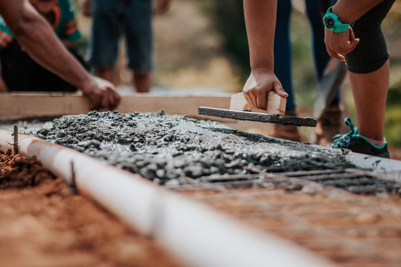 Workers screeding a fresh concrete slab, the foundation under most east Memphis suburban homes